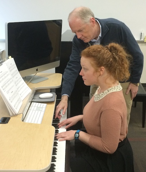 Ken instructs a student on piano.